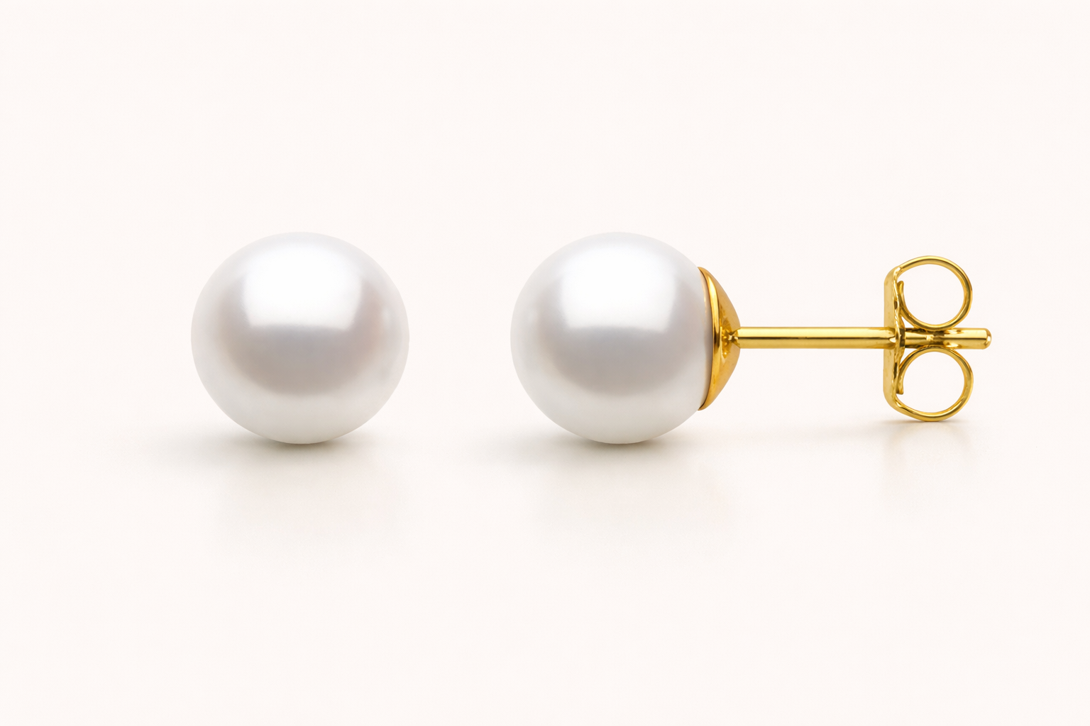 Pearl stud earrings with gold posts on a white background
